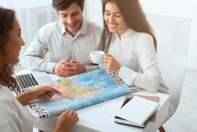 Reiseberatung mit Weltkarte im Reisebüro