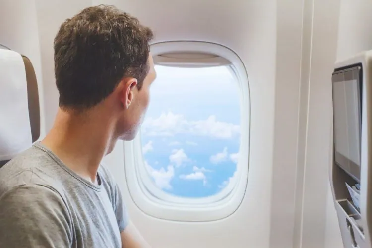 Blick durch das Flugzeugfenster über den Wolken